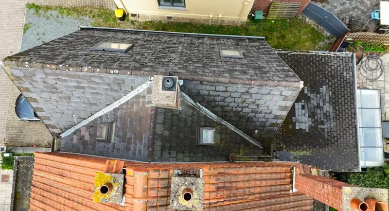 Avant rénovation : ancienne toiture en ardoises artificielles grises, usées et dépareillées, vue du drone