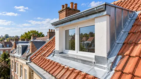 Lucarne rénovée avec solins et habillage en zinc sur une toiture en tuiles terre cuite