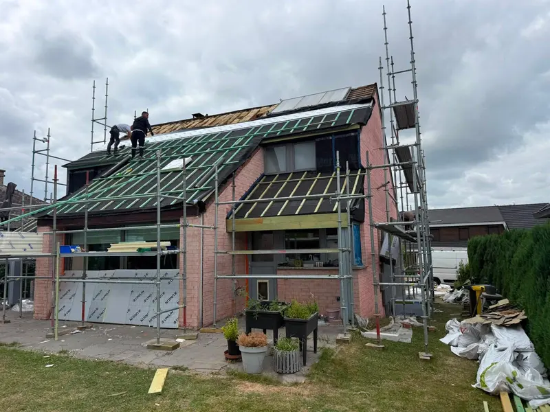 Rénovation complète d’une toiture : maison sous échafaudage, sous-toiture verte et contre-lattes posées, couvreurs sur le versant