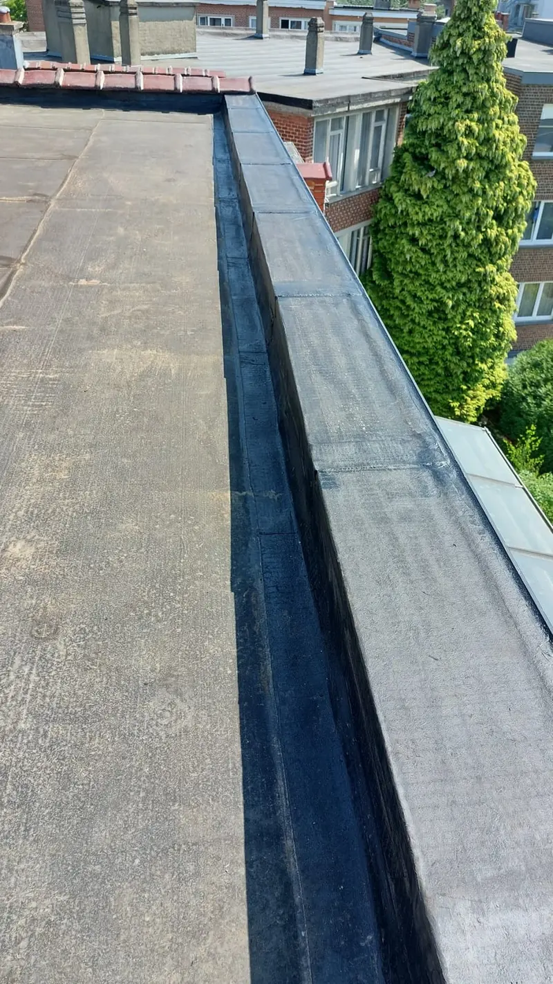 Relevé d’étanchéité en roofing sur l’acrotère d’une toiture plate, toits et jardins en contrebas