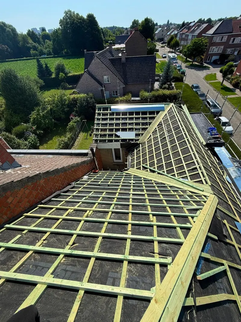 Isolation par l’extérieur en cours vue du drone : panneaux de sarking couverts d’un écran noir et contre-lattes sur toute la toiture
