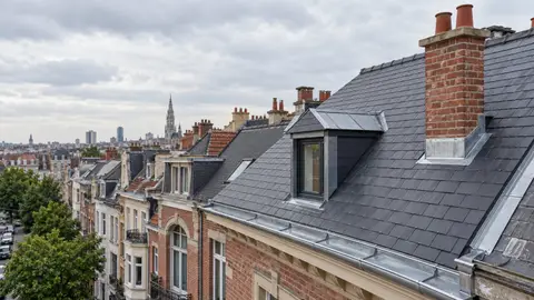 Toiture en ardoises naturelles d’une maison bruxelloise, avec lucarne et cheminée en briques