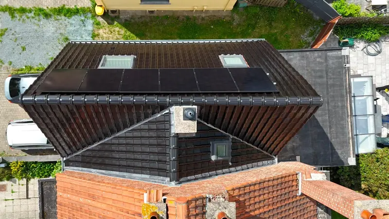 Après rénovation : toiture en tuiles anthracite avec fenêtres de toit et panneaux solaires, souche de cheminée reprise, vue du drone