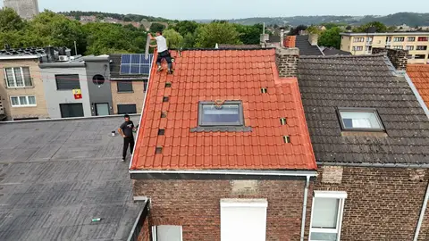 Toiture neuve en tuiles rouges avec fenêtre de toit vue du drone, maison de rangée en briques, couvreur au faîtage