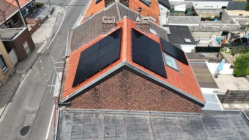 Toitures en tuiles rouges neuves avec panneaux solaires sur des maisons mitoyennes, vue du drone