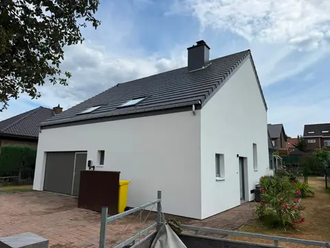 Villa quatre façades blanche après rénovation de la toiture en tuiles grises, cheminée neuve et fenêtre de toit
